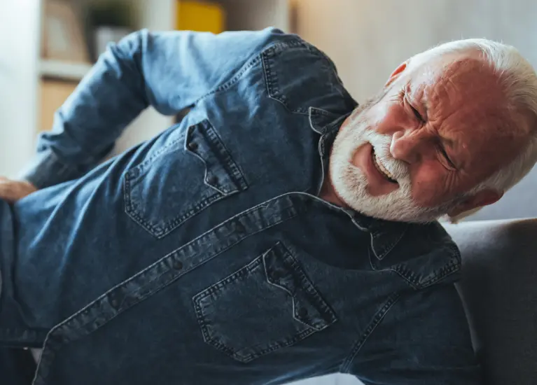 A man lying on the floor with his back and his hand on his hip