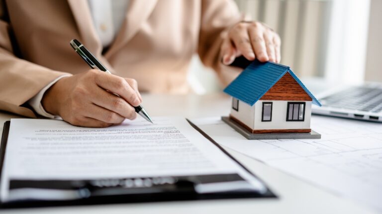 Person with house and insurance paperwork